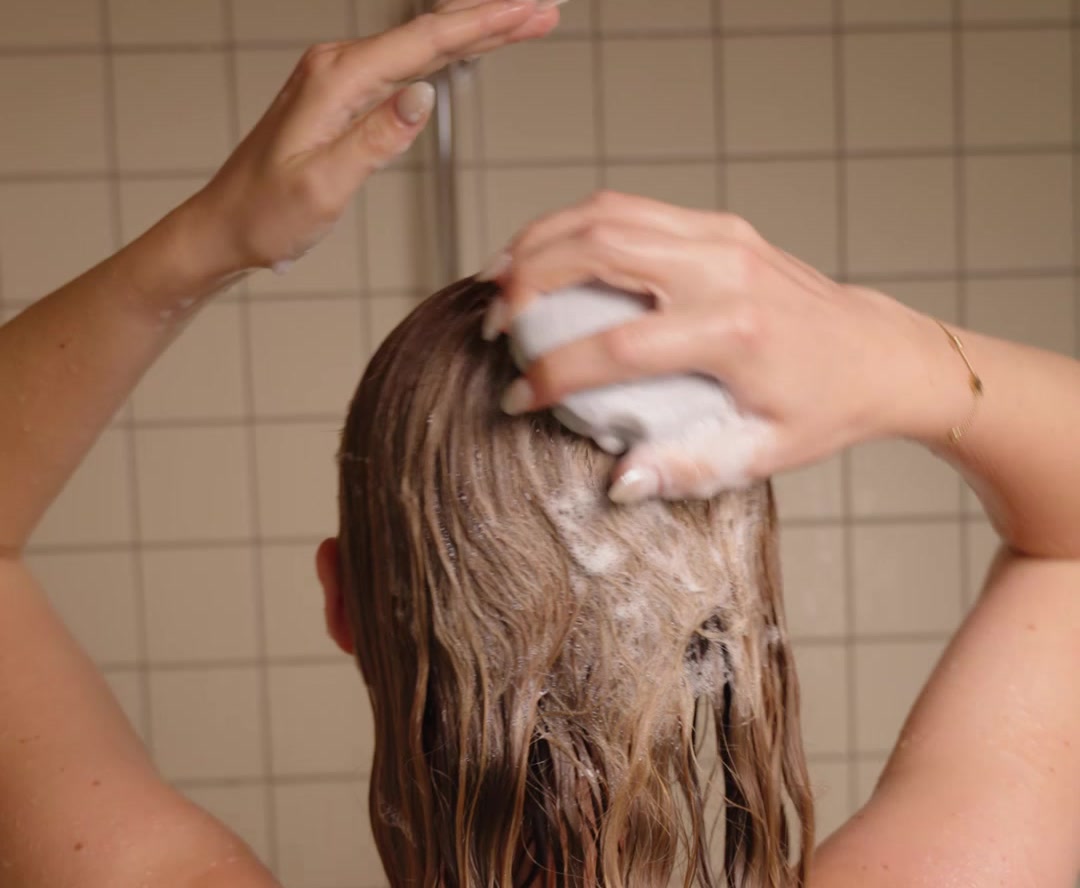 Haar inzepen met een shampoo bar onder de douche