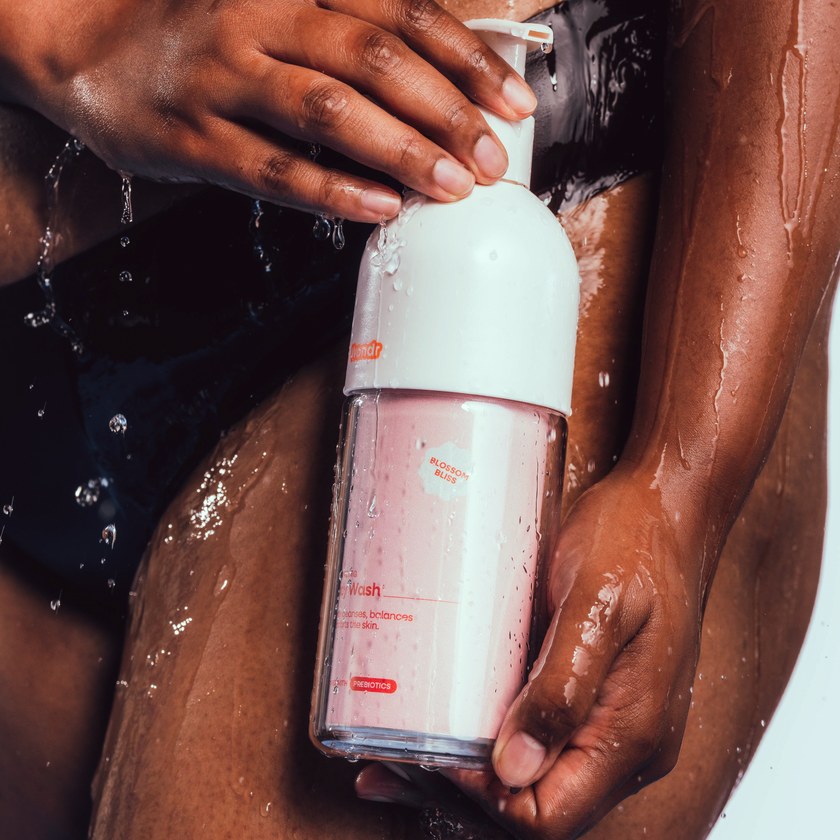 Hand met een WONDR pompfles onder de douche